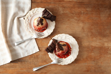 Delicious poached pears in red wine with chocolate sauce on plates