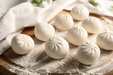 Raw Chinese dumplings on wooden board