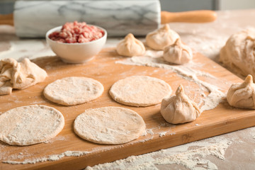 Raw Chinese dumplings and ingredients on kitchen table