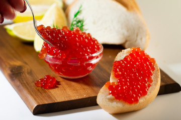 red caviar in glassware on wooden background with space for text