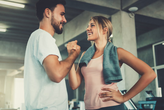 Attractive young couple handshaking after workout in fitness gym., Portrait of man and woman couple love are working out training together., Couple fitness and healthy concept.