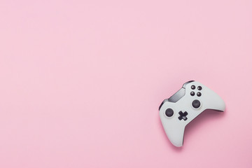 White gamepad on a pink background. Concept game on the console, computer games. Flat lay, top view.
