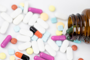 Pill bottle spilling out. colorful pills on to surface tablets background. top view. drug medical healthcare concept.