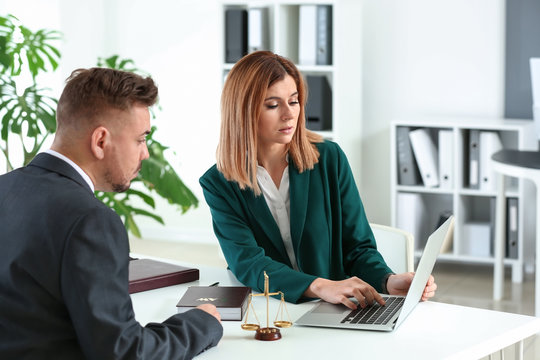 Female Lawyer Working With Client In Office