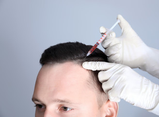 Man with hair loss problem receiving injection in clinic