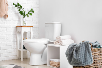 Modern interior of restroom with ceramic toilet bowl