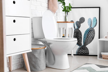 Modern interior of restroom with ceramic toilet bowl