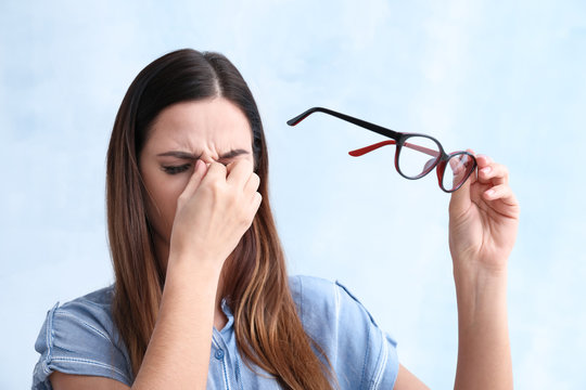 Portrait of woman with bad sight on color background