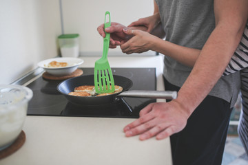 Husband and wife bake heart shaped cookies together.