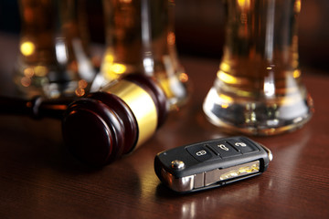 Drinking and driving concept. Car key on a wooden table, pub background