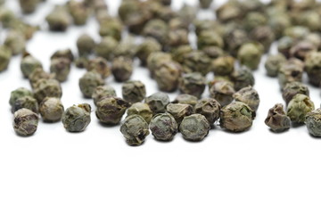 Dry green pepper pile, macro peppercorn isolated on white