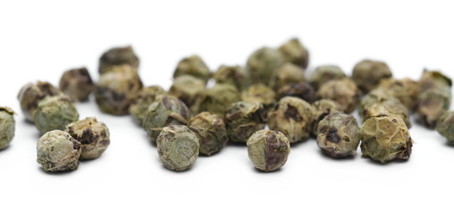 Dry green pepper pile, macro peppercorn isolated on white