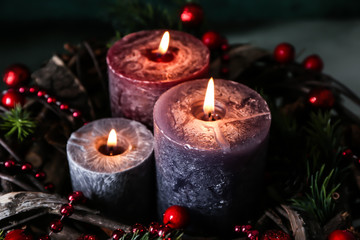 Christmas wreath with burning candles, closeup