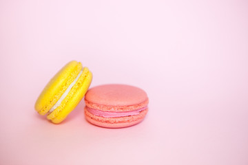 Fototapeta premium Two macaroon dessert on pink background, beautiful card with sweet food