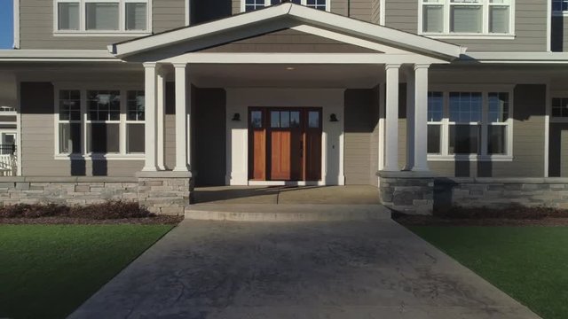 Beautiful new custom home, camera pulls out from front door to reveal house.