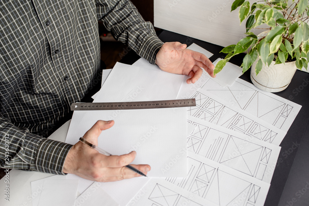 Wall mural ux website designer drawing wireframe sketch of prototype, framework, layout future project. creativ