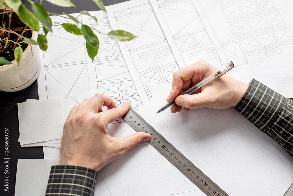 Wall mural ux website designer drawing wireframe sketch of prototype, framework, layout future project. creativ