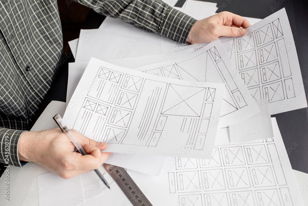 Wall mural ux website designer drawing wireframe sketch of prototype, framework, layout future project. creativ
