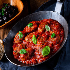 Baked mini meatballs in tomato sauce with basil
