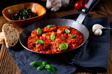 Baked mini meatballs in tomato sauce with basil