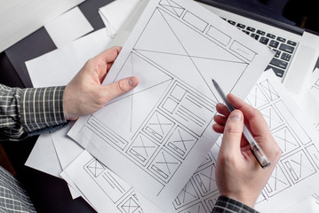 UX website designer drawing wireframe sketch of prototype, framework, layout future project....