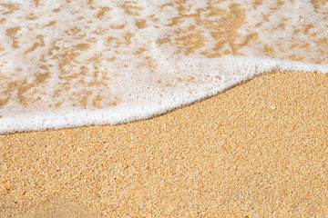 Waves of the sea on a brown sand empty beach