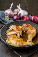 Grilled chicken legs with spices, onion and garlic.