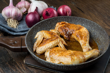 Grilled chicken legs with spices, onion and garlic.