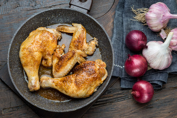 Grilled chicken legs with spices, onion and garlic.