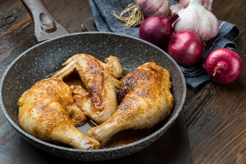 Grilled chicken legs with spices, onion and garlic.