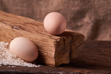 Bunch of rice and uncooced eggs on wooden table. Concept health food