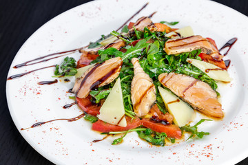 Salad with grilled tuna, Parmesan, tomatoes and arugula, flavored with balsamic sauce and olive oil