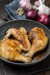 Grilled chicken legs with spices, onion and garlic.
