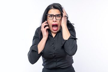 Afraid and shocked young business woman receiving bad news over her cell phone