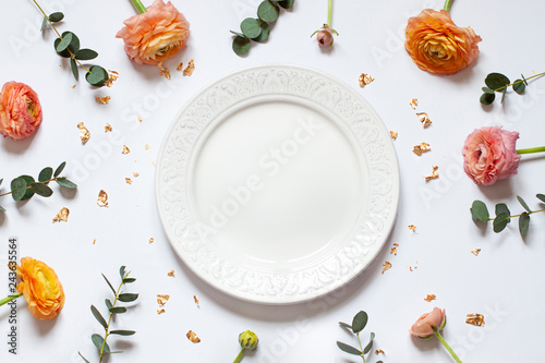 Empty plate concept flat lay with floral decorations on the white backdround. Top view Valentines day, Mothers day or Easter card. Copy space