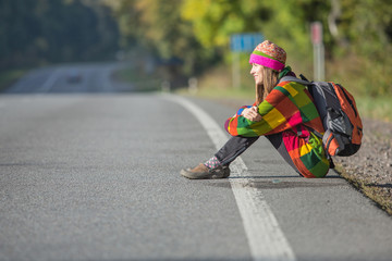 Beautiful traveler on the road hitchhiking