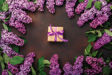 A bouquet of lilacs with gift box on rusty background . Mother's day