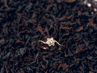 background of black tea leaves. precious ring. decorations.