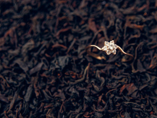 background of black tea leaves. precious ring. decorations.
