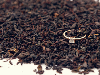 background of black tea leaves. precious ring. decorations.