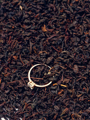 background of black tea leaves. precious ring. decorations.