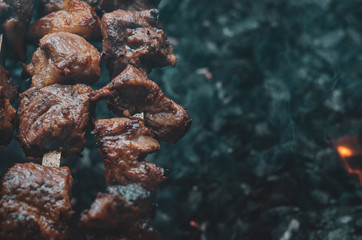 pieces of grilled meat on skewers. Skewers with pieces of mutton meat lie on the grill. The concept of picnic and country rest. Street food