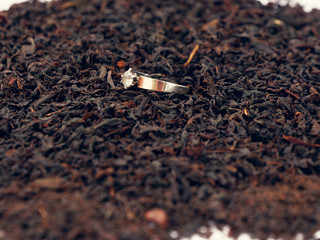 background of black tea leaves. precious ring. decorations.