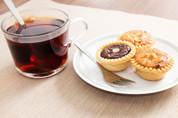 Tea time with hot tea and dessert tarts