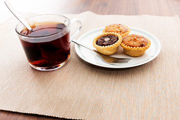 Tea time with hot tea and dessert tarts
