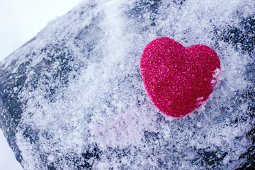 Fototapeta premium Heart in the snow. Valentine's day background with heart.Red heart on white snow, a background about love, a background to the day of lovers, a hot heart in white winter