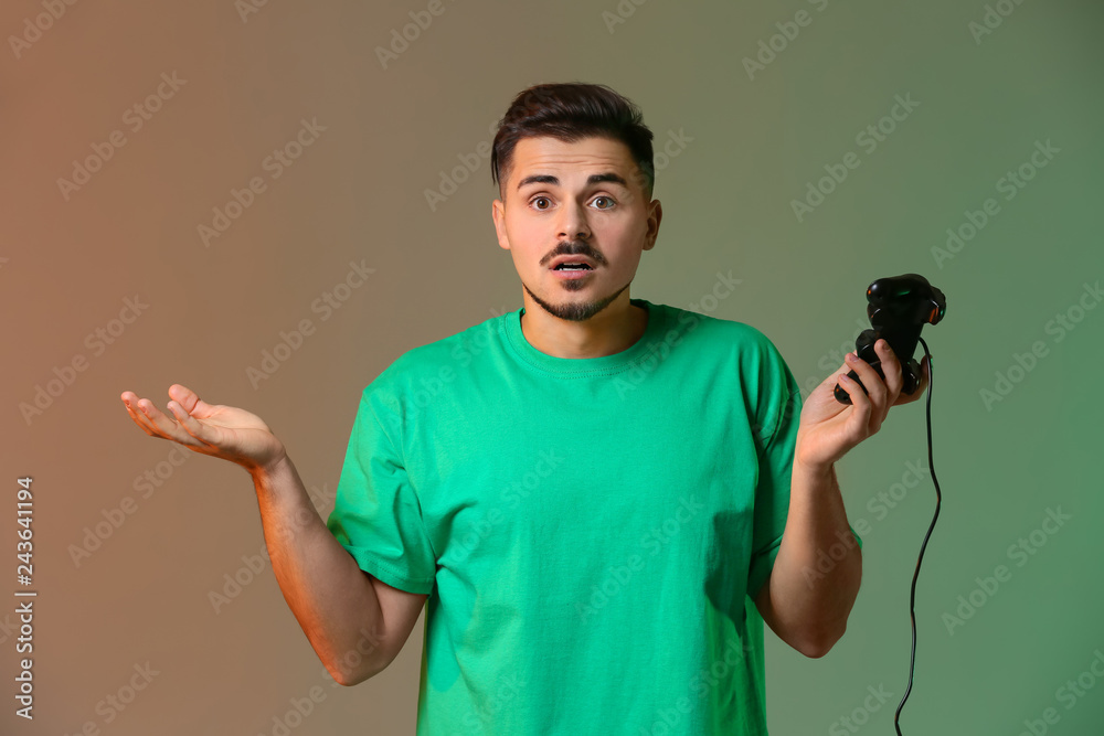 Wall mural young man after losing video game on color background