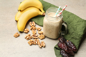 Mason jar of smoothie with dates, bananas and nuts on table