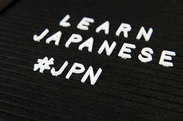 Fototapeta na wymiar Learn Japanese JPN abbreviation, simple sign on black background, great for teachers, schools, students