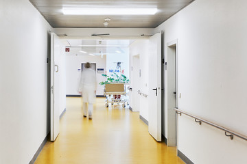Krankenhaus mit Flur und Bett mit Personen und Bewegungsunschärfe